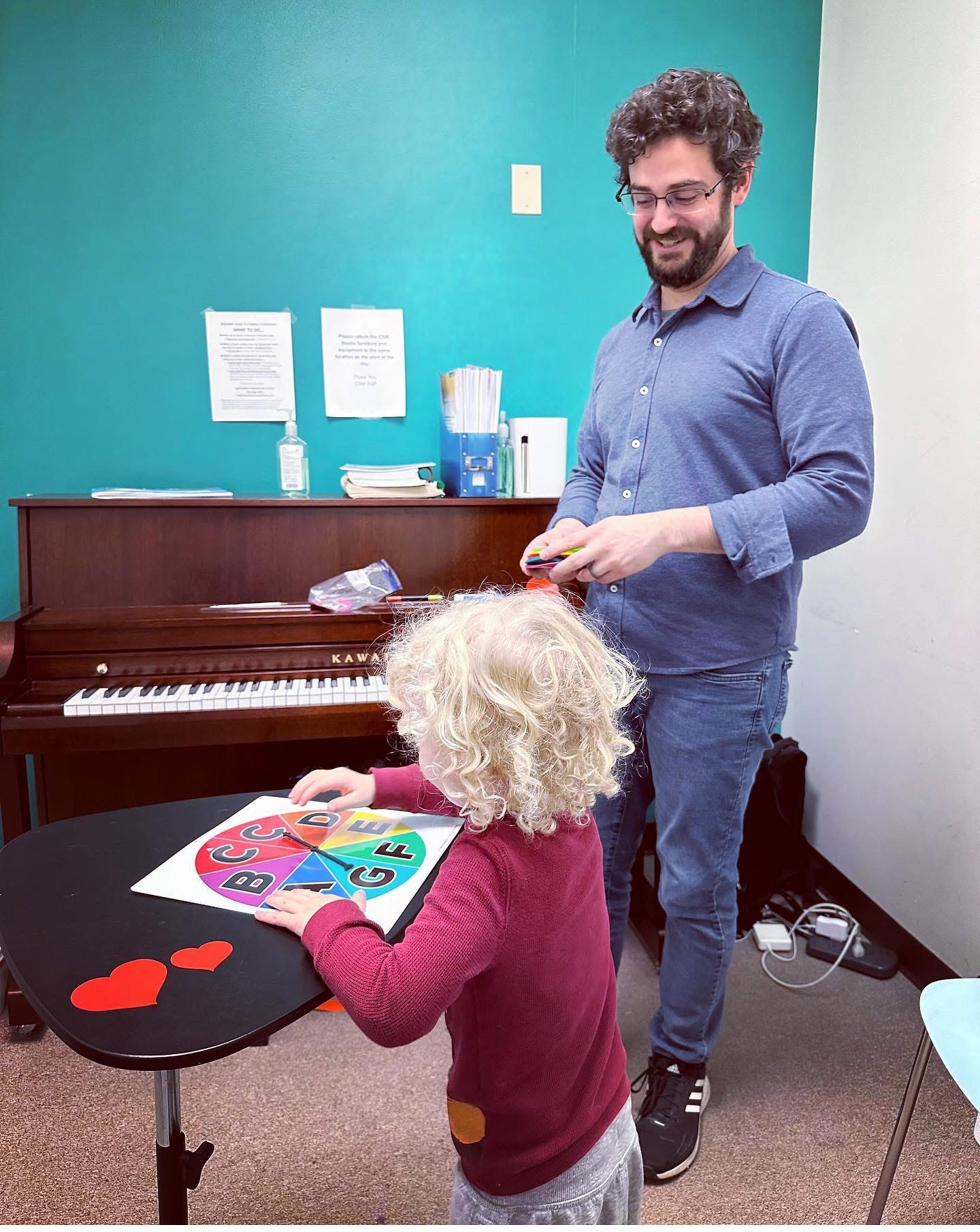 Young child working on music activity with teacher at CSM